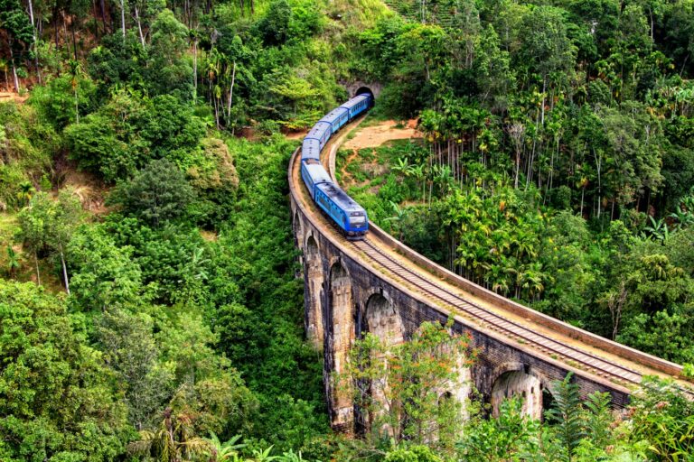 A blue train crossing the Nine Arch Bridge near Ella in the tea country of Sri Lanka